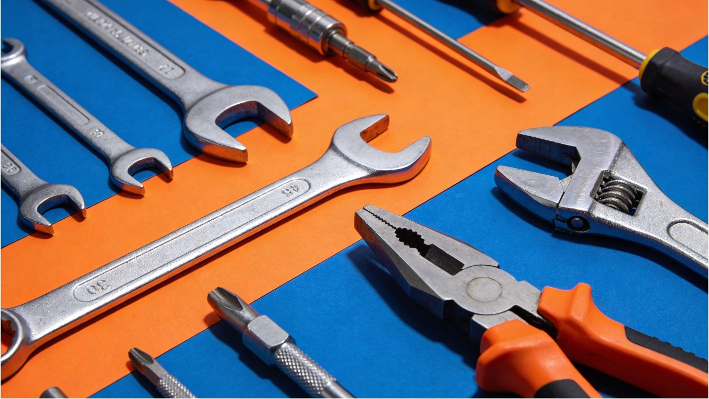 Hand tools including wrenches screwdrivers and pliers displayed in a clean organized grid